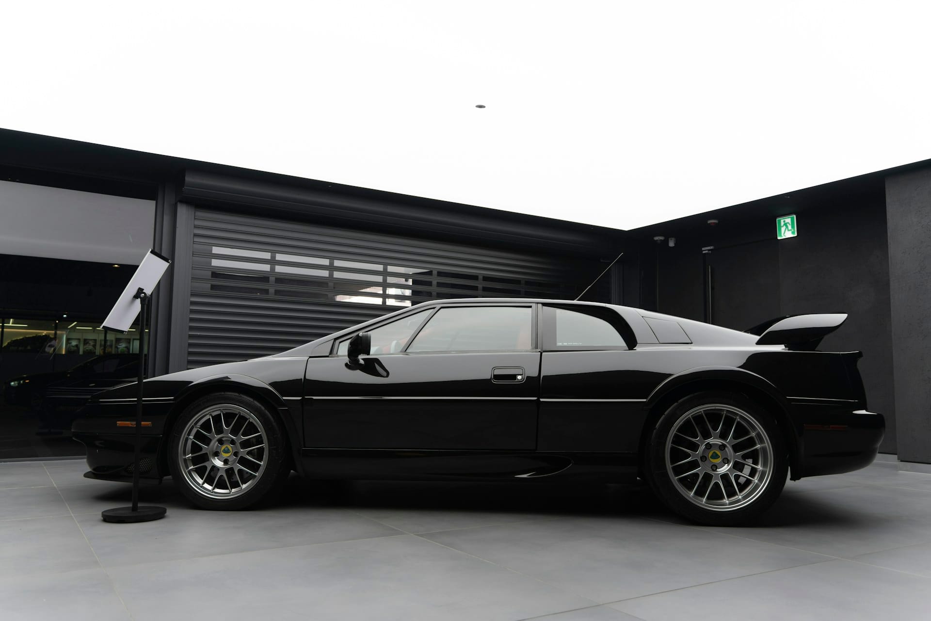 Professional detail team working on a glossy sports car parked outside, at the client's location